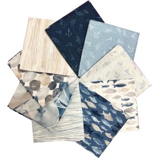 Das Bild zeigt 9 gefaltete Stoffstücke der Kollektion Set Sail aufgefaechert in einem Kreis. Die Farben sind verschiedene blautoene, beige, sand und helle grautoene. Motive sind klassische Meeresmotive wie Fische, Muscheln oder Kieselsteine.