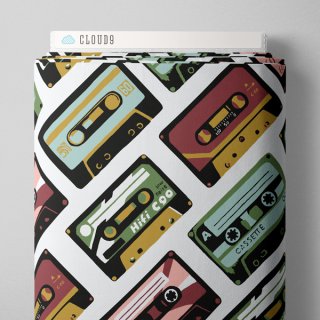 Die Ansicht zeigt den oberen Ausschnitt des Stoffballens des Canvasstoffes Casettes. Es sind Kassetten in burgund, gruen, rose und hellblau mit schwarzer Umrandung zu sehen. Sie sind in diagonaler Richtung auf den Stoff gedruckt.