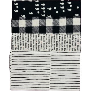 Das Bild zeigt vier mit Versatz aufeinander gelegte Stoffstücke in den Farben schwarz und weiss mit grafischen Mustern.