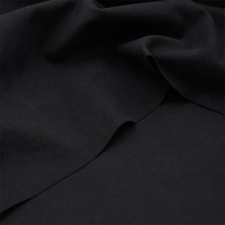 Das Bild zeigt den Stoff  Heavy Washed Canvas in black, also in schwarz. Dieser Stoff liegt leicht aufgefaechert auf einem Tisch.