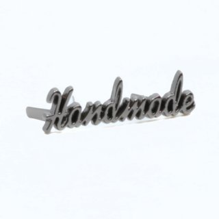 Auf dem Bild ist das Metall-Label Handemade in gunmetal zu sehen. Handemade ist als Kontur ausgeschnitten.