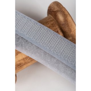 Das Bild zeigt das hellgraue Hakenklettband auf einer Holzspule.