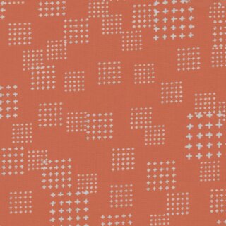 Das Bild zeigt den orangefarbenen Baumwollstoff mit kleinen grauen Kreuzen.