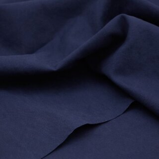 Das Bild zeigt den Heavy Washed Canvasstoff in  indigo night. Es ist ein klarer, leuchtender, dunkler blauton. Der Stoff liegt leicht aufgefaechert auf einem Tisch.