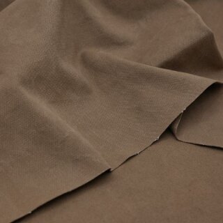 Das Bild zeigt den Heavy Washed Canvasstoff in sattle. Es ist ein Sattelbraun. Der Stoff liegt leicht aufgefaechert auf einem Tisch.